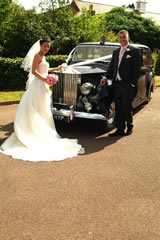 Bride and groom with car