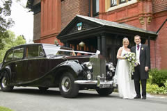 Wedding car with bride and groom